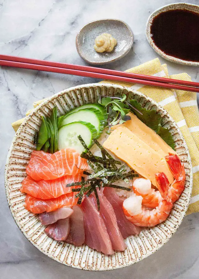 Chirashi Sushi is a traditional Japanese Sushi served in a rice bowl  topped with sea food